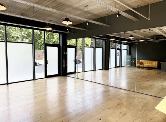 The mirror wall, running the length of the room, with the frosted street frontage opposite.