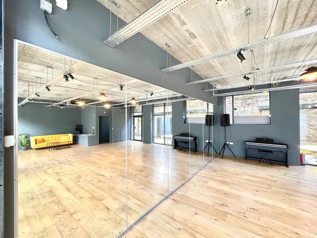 The room from the door, with the pianos and the seating area beyond